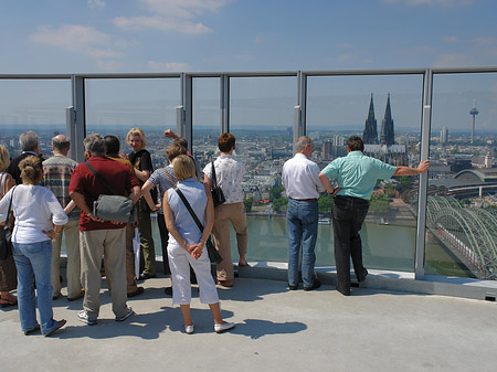 Besucher gucken auf Kölner Dom und Hohenzollernbrücke